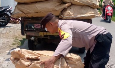 Bhabinkamtibmas Polsek Pebayuran Membantu Membereskan Barang Muatan Pengendara Mobil Pick Up Yang Terjatuh
